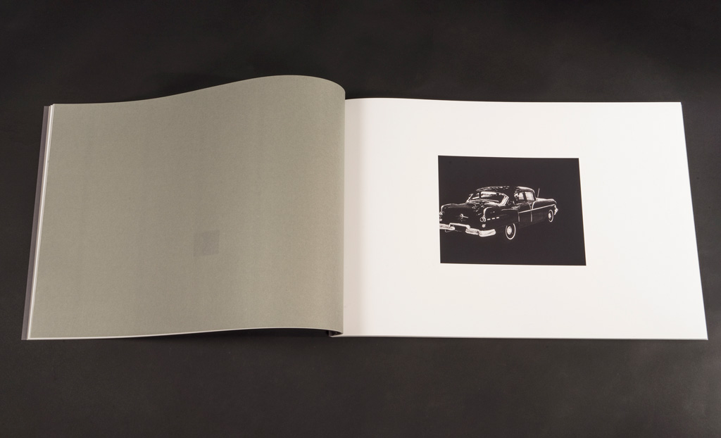 "Redress Papers" open to a spread with a blank verso and a vintage car on the recto.