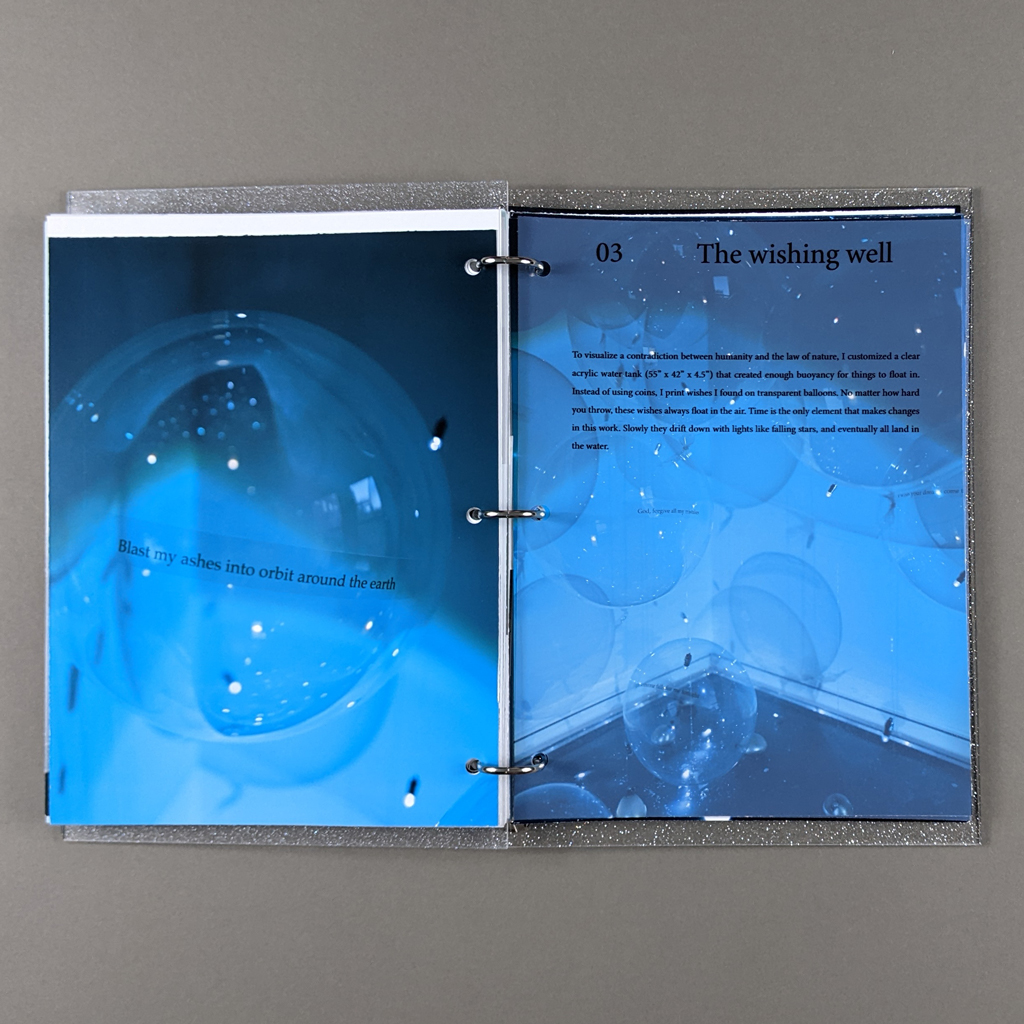 "You are the star" inside spread. Verso: A monochrome blue photograph of a balloon with text reading "Blast my ashes into orbit around the earth". Recto: A monochrome blue photograph of the installation, The Wishing Well, with title text and a paragraph of explanatory text on a transparent overlay. 