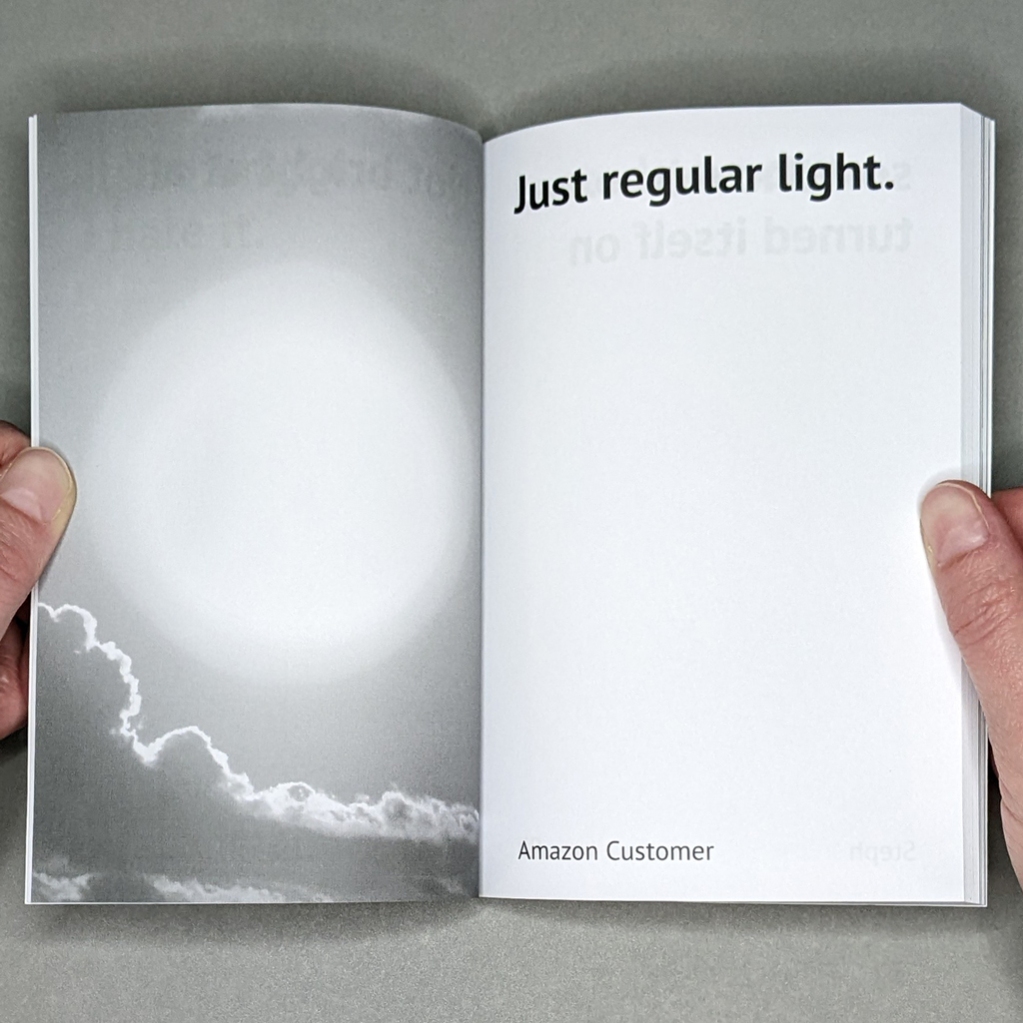 One Star inside spread. Verso is a grayscale stock photo of the sun above a cloud. Recto reads: “Just regular light. / Amazon Customer”]